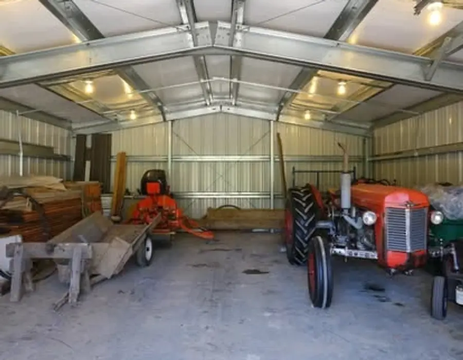Inside picture of a c-channel building with farm equipment in it.