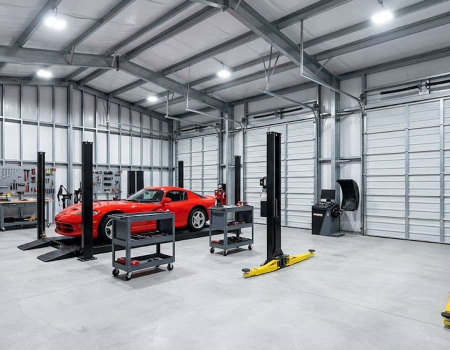 C-channel garage steel building interior fitted out for vehicle restoration work.